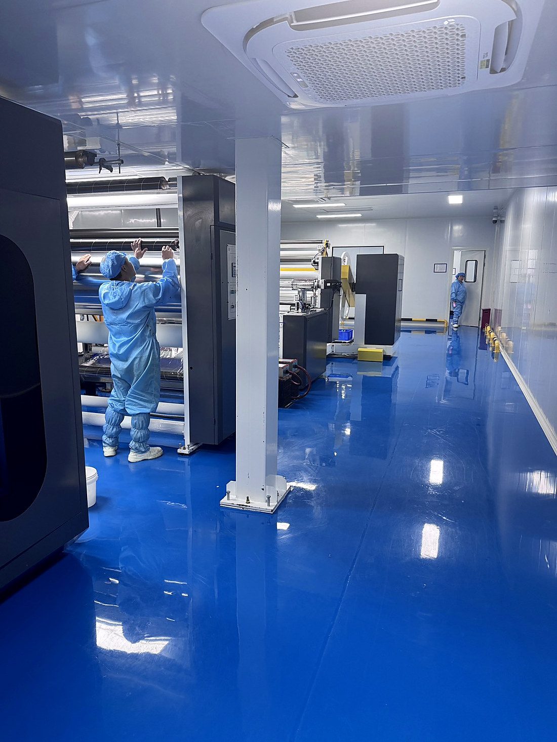 ทีมช่างควบคุมเครื่องจักรในห้องคลีนรูม